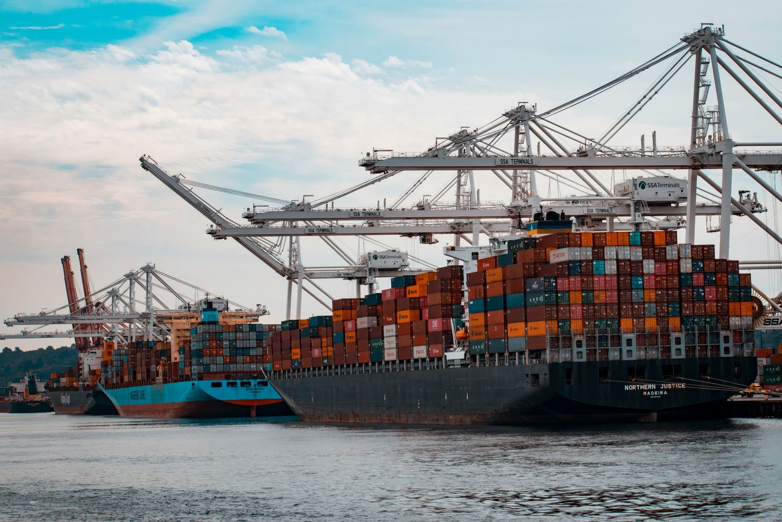 Gantry cranes loading shipping containers onto vessels at a port terminal